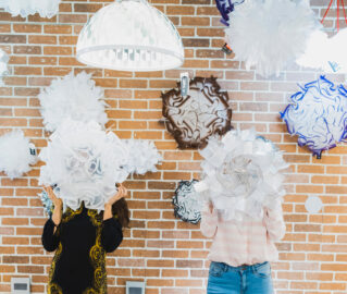 two people hiding behind pendant lights - Casa di Luce Showroom