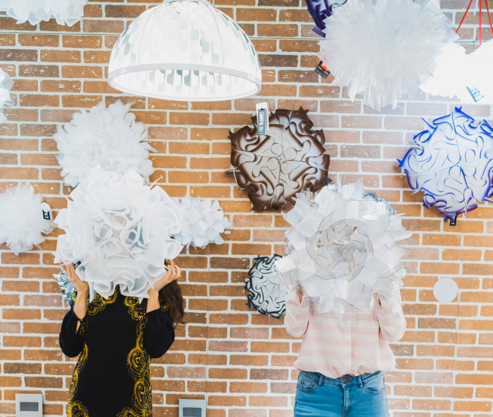 two people hiding behind pendant lights - Casa di Luce Showroom