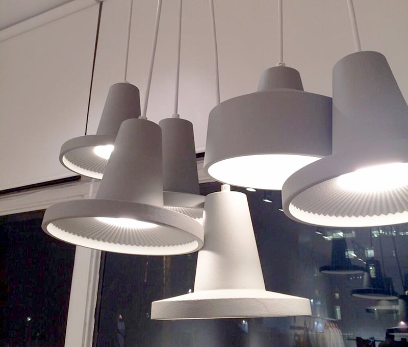 Jonathan Sabine’s cluster of seven pendants are handmade from sand cast aluminum and moulded using 3-D printed nylon. Though the lights themselves are beautiful, it is the moulds — displayed nearby — that impress the most. The pendants are created by pouring molten metal into different impressions in sand with the same computer-generated pattern. Sabine computer-generated new forms and interior patterns and a 3D printer brought these to life in laser-sintered nylon.