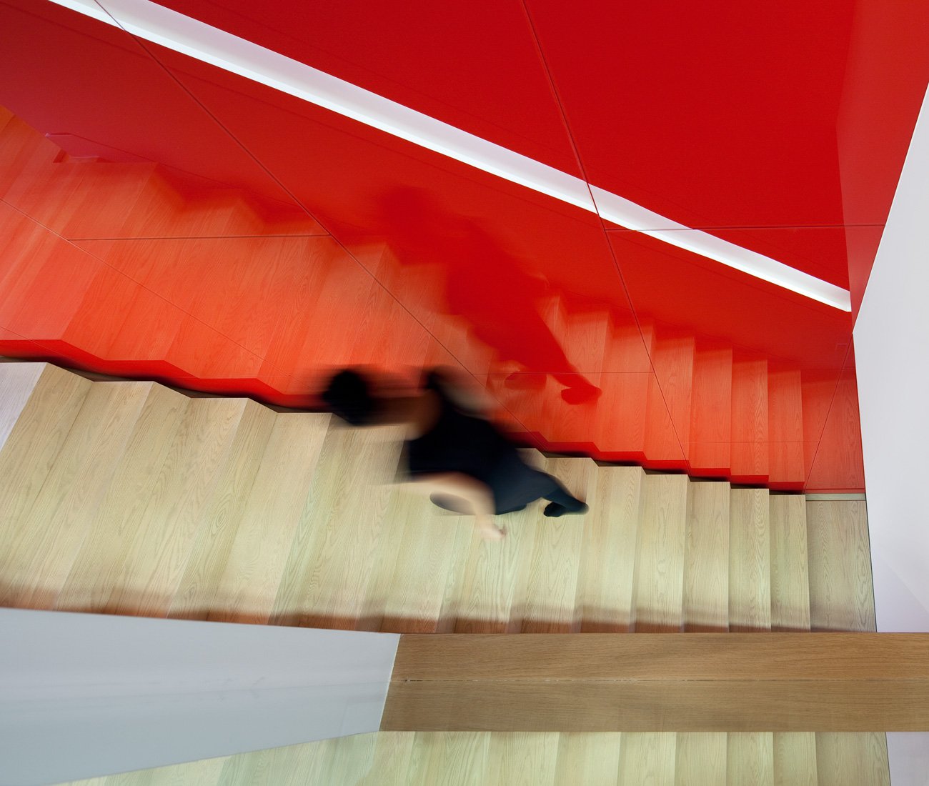 Red, back-painted glass wall that runs the entire height and length of the Mediterranean home design