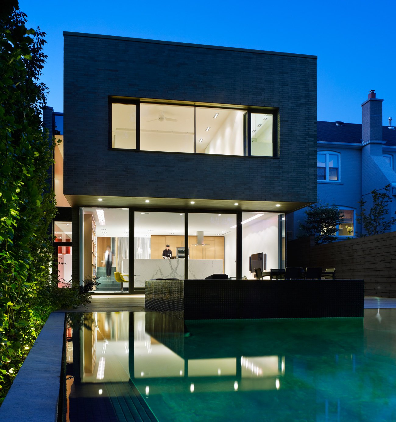 Mediterranean home design - Exterior view with sliding glass door separating the living space from the deck. The infinity pool with its inset hot tub - Kohn Shnier architects