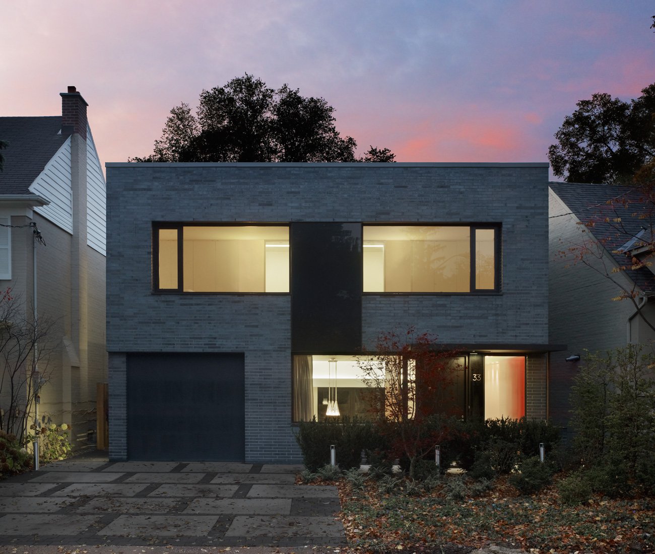 flat-roofed modern home Toronto with iron-spot brick and grey-tinted windows - Kohn Shnier architects