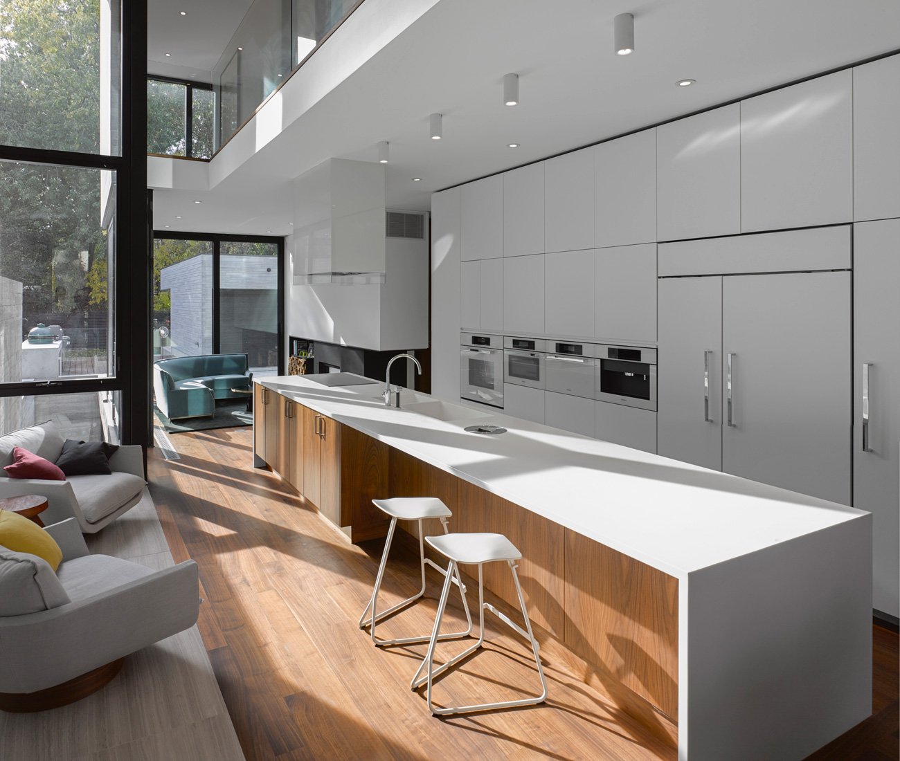 A Five-metre-long island is topped in cool Corian and a modern lacquered cabinetry in a modern home kitchen | Kitchen Design Ideas