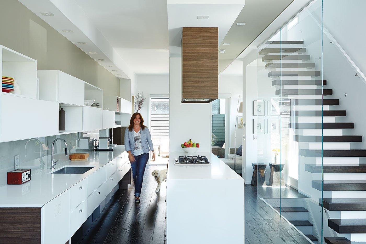 Modern townhouse in Toronto - Female walking in a kitchen with white cabinetry
