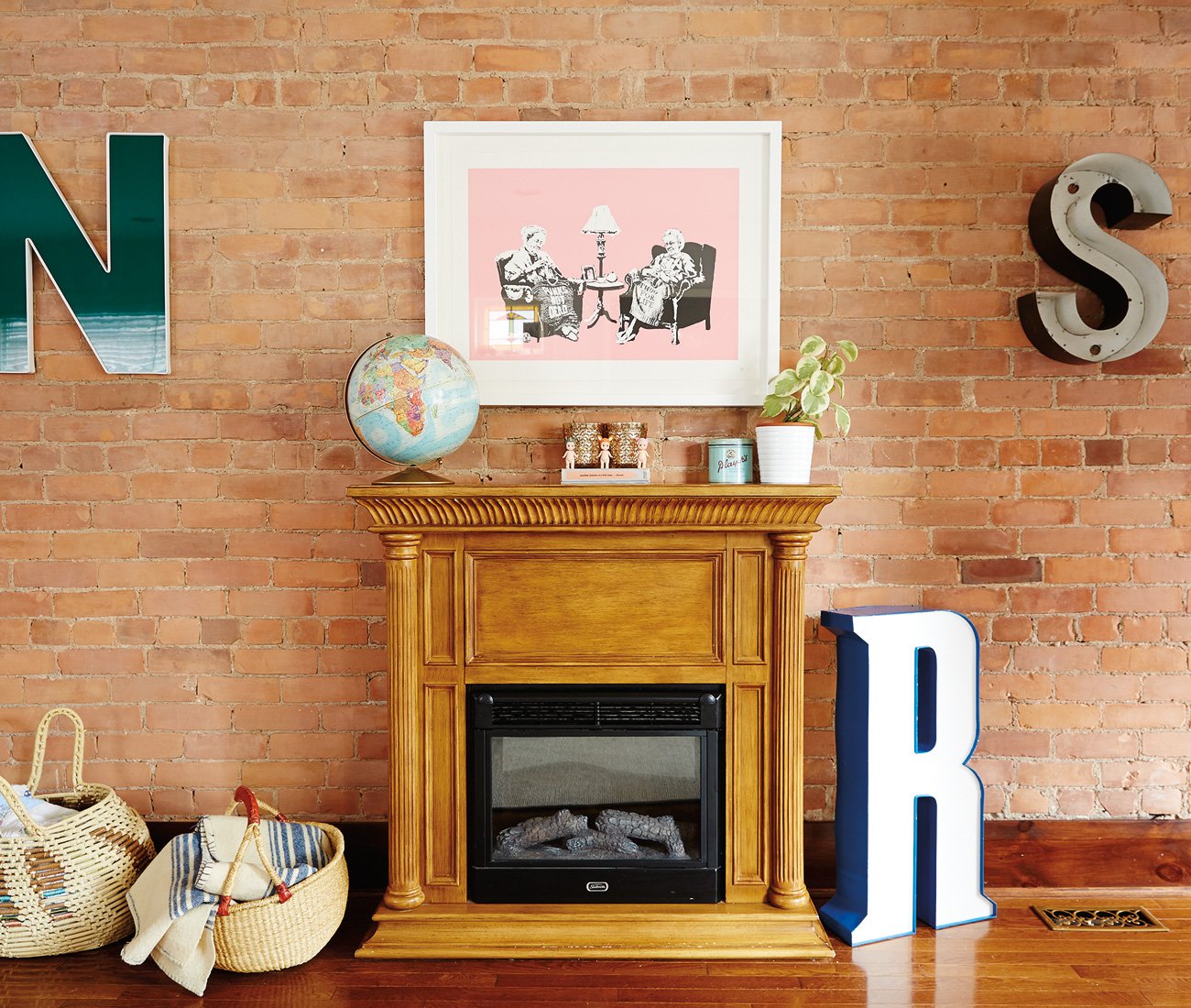 curate vintage decor - Jo Arnott globes and Kewpie dolls with Clay Rochemont's Banksy above the fireplace