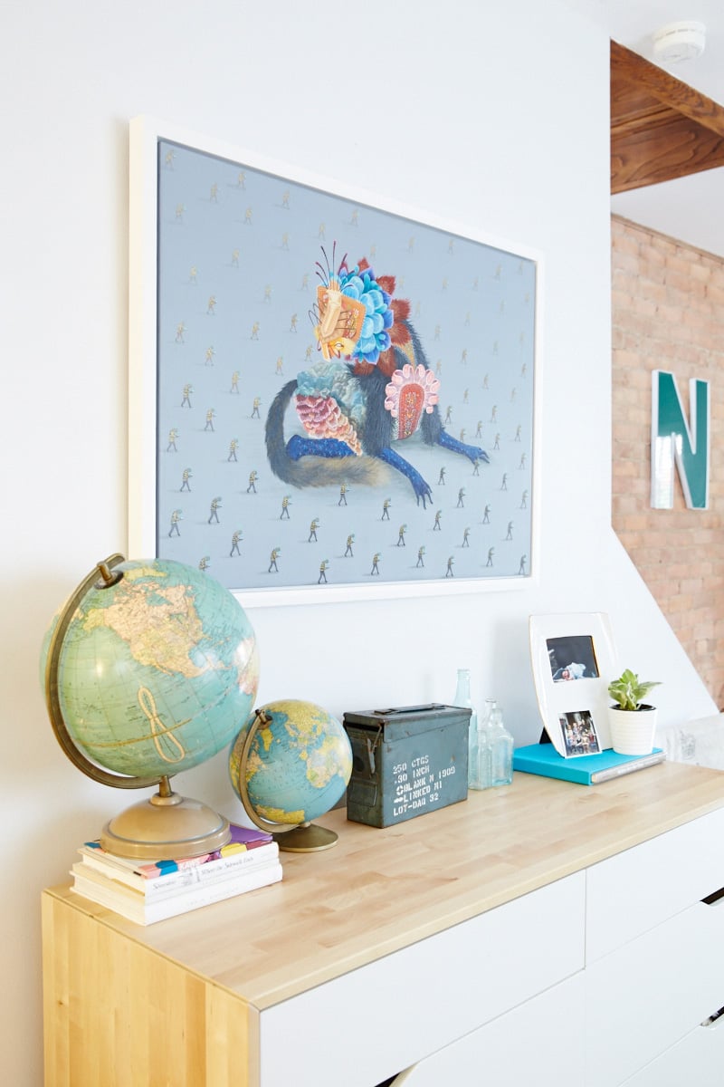 Jo Arnott globe collection sits underneath a Curiot painting entitled "New Slaves"