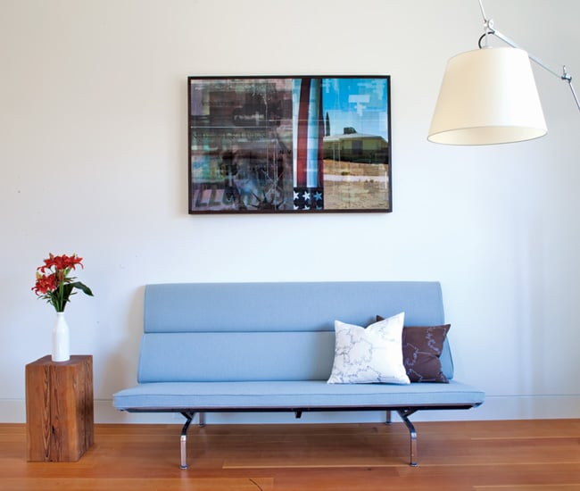 Artwork by Bill Douglas hangs over an Eames Compact sofa