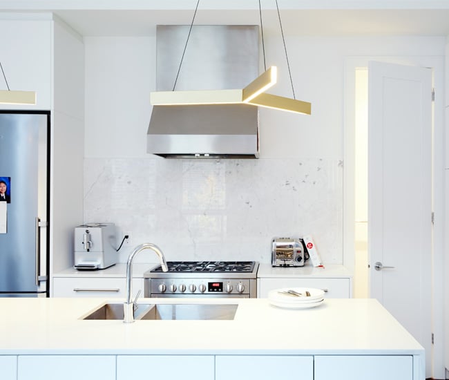 A triangle shaped modern light is brightening the island space