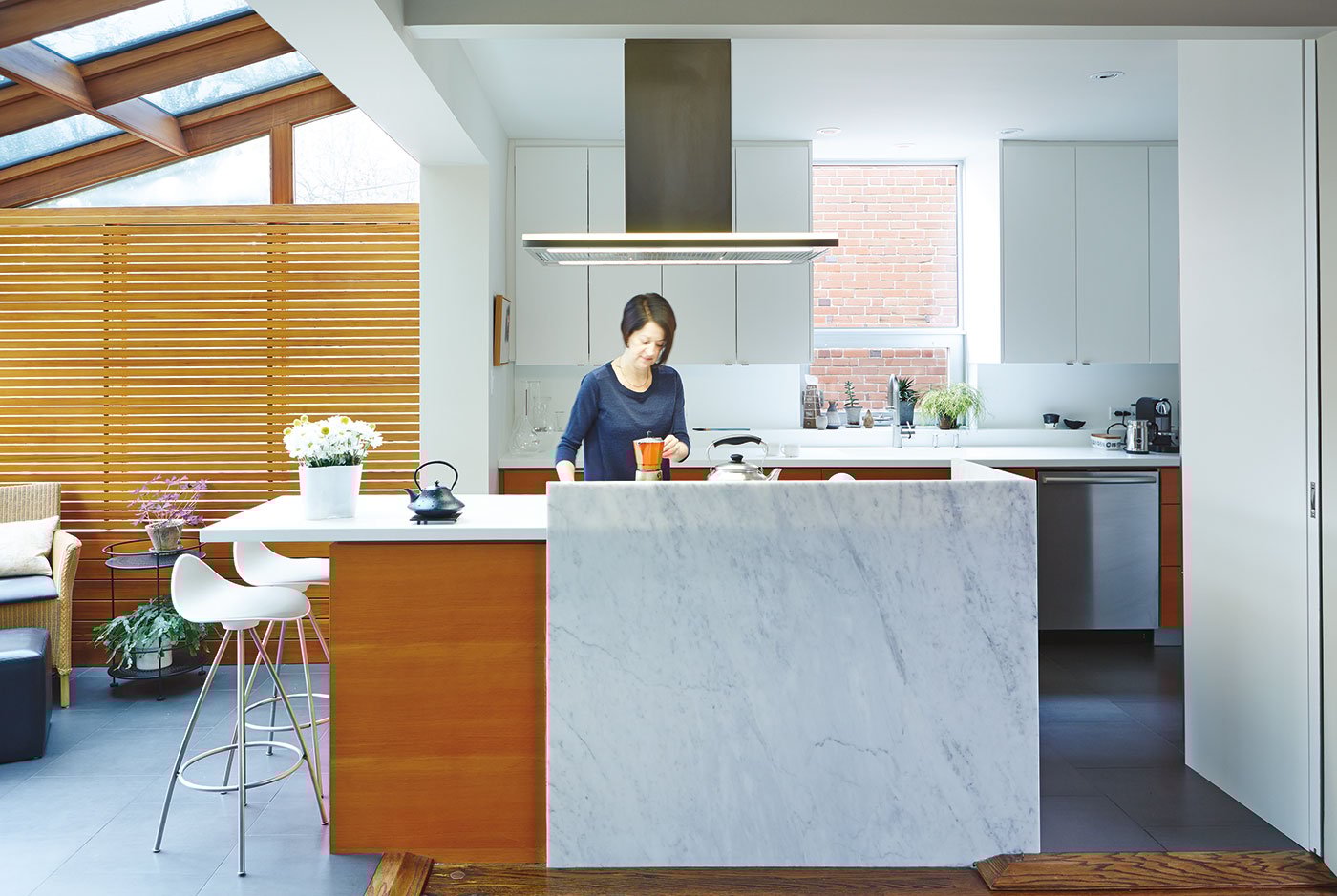 A female person is in the kitchen preparing the coffee with a moka. | Kitchen design Ideas