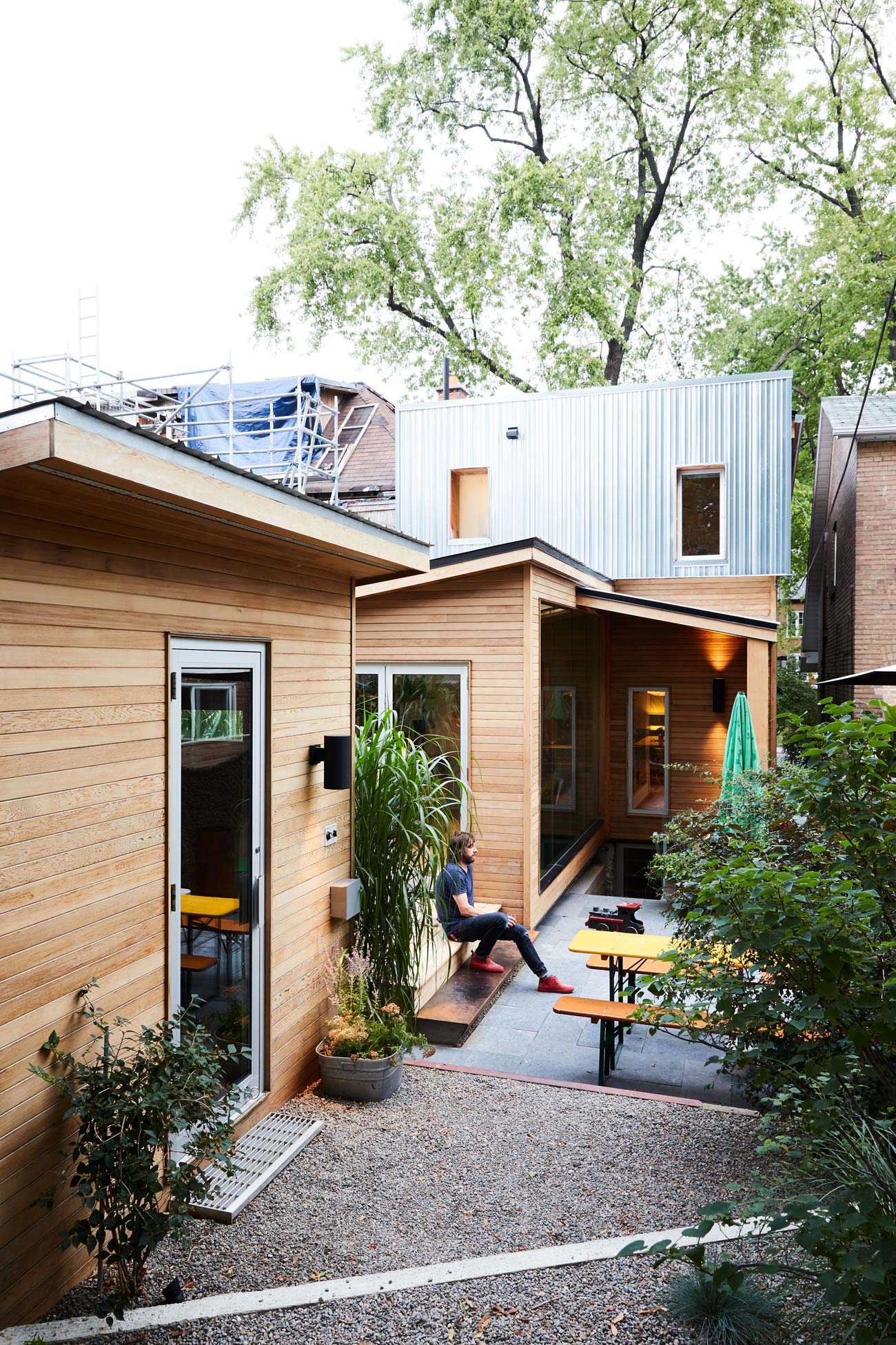 Backyard view of Thrush Holmes High Park home with a deck bridging the solarium and sauna