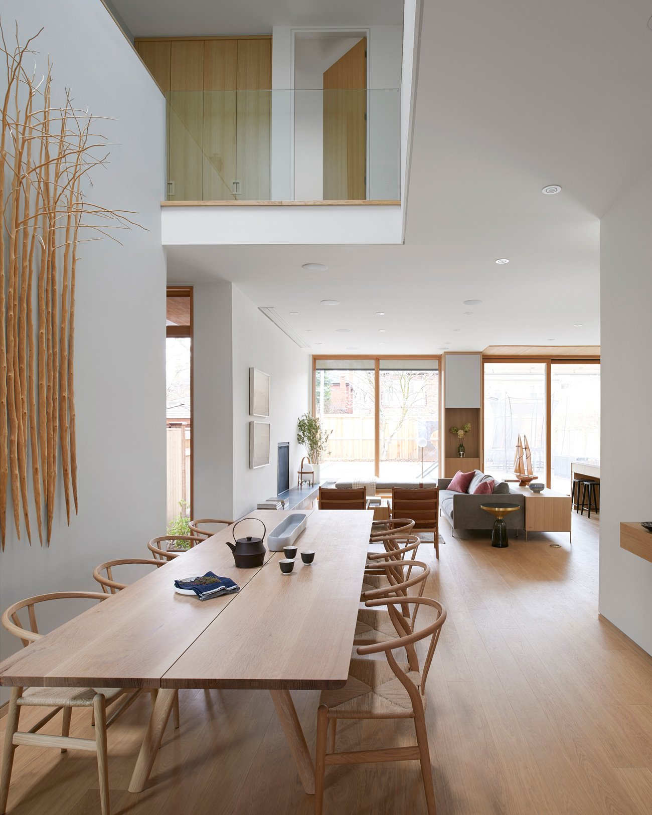 A landing overlooks the front foyer and a 3.6-metre-long table by Heidi Earnshaw in the dining room - Leaside House by Arriz + Co and Altius Architecture