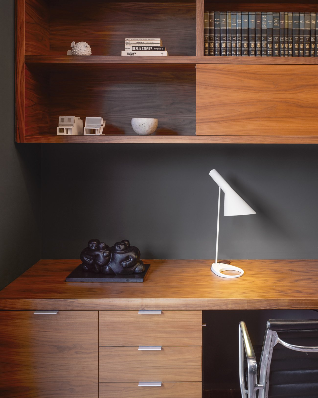 Custom wall-mounted walnut desks and shelving in a modern home office designed by architect Paul Raff, showcasing functional and stylish workspace solutions.