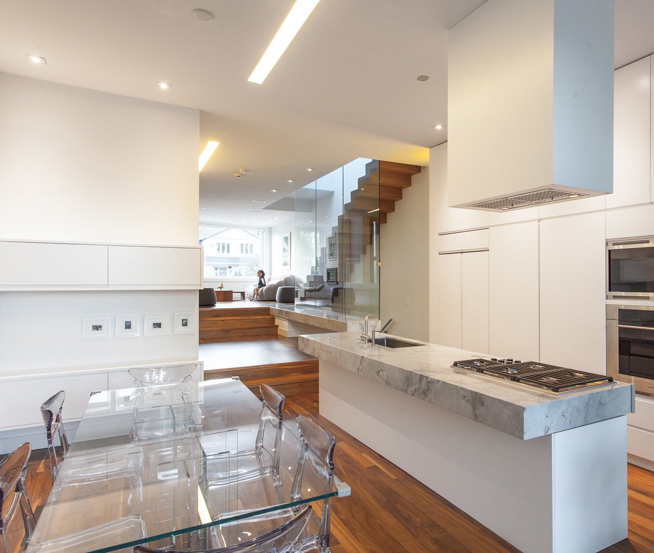 Modern kitchen and family room in a narrow lot home, featuring seamless transitions between spaces in a family-friendly design by JA Architecture Studio
