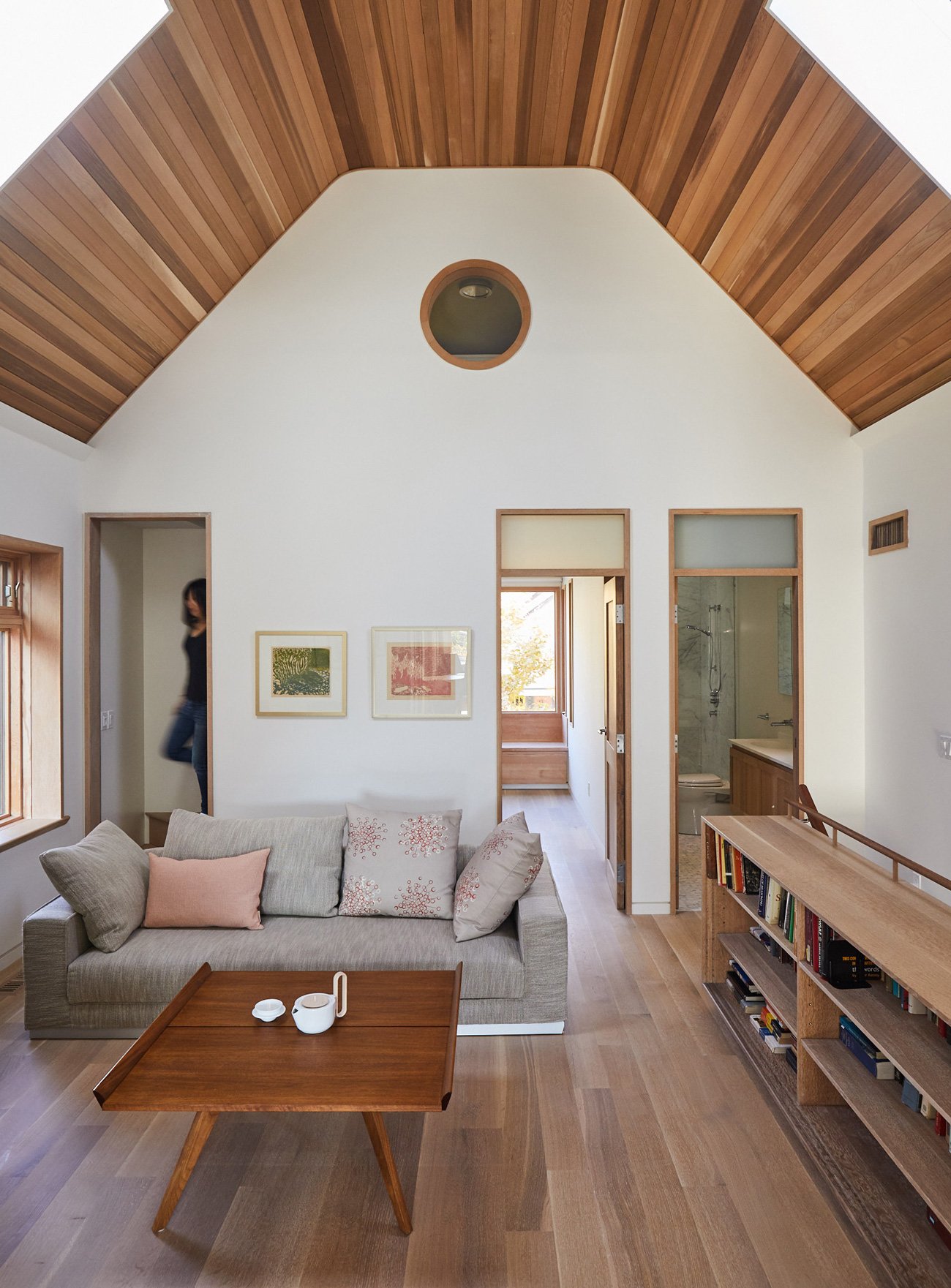 Upper-level room with cedar tongue-and-groove ceiling and wood-burning stove, embodying the charm of a Japanese cabin. Studio Junction design