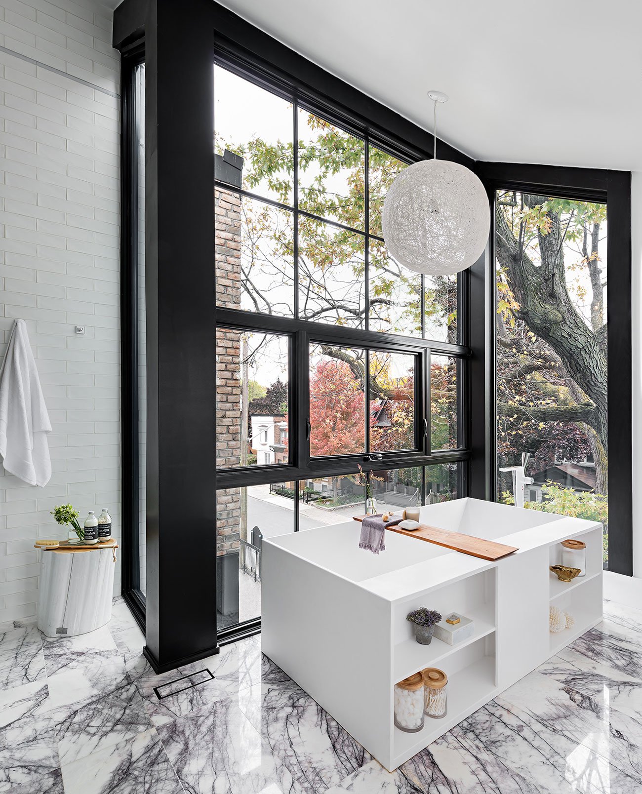 Modern Bathroom Designs - A sleek rectangular bathtub set by floor-to-ceiling windows, offering stunning views and natural light.