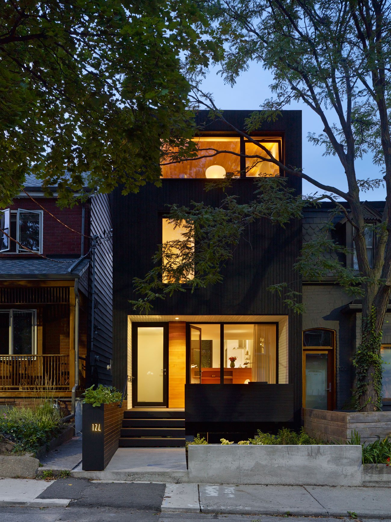 Black wood siding covers the exterior of the modern urban home - Great Lake Studio design by Great Lake Studio