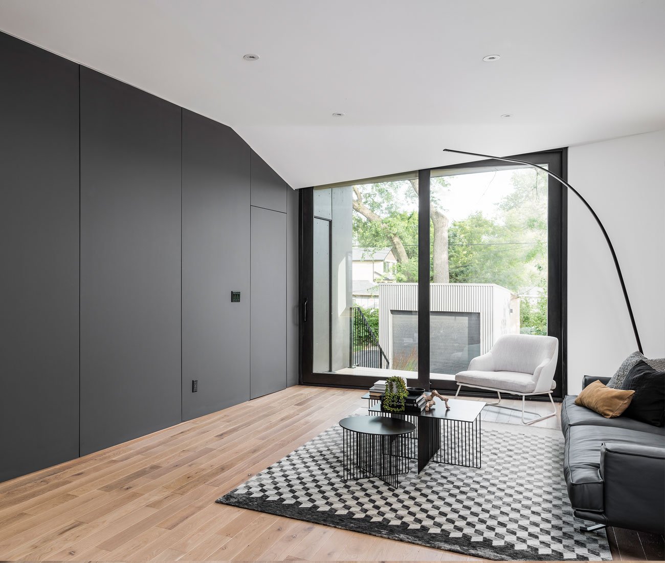 Phaedrus Studio Tesseract House Designlines Magazine Long Branch Home Living room with angled drywall mimicking faceted exterior, ceiling pocket concealing sliding door track. Phaedrus Studio Tesseract House