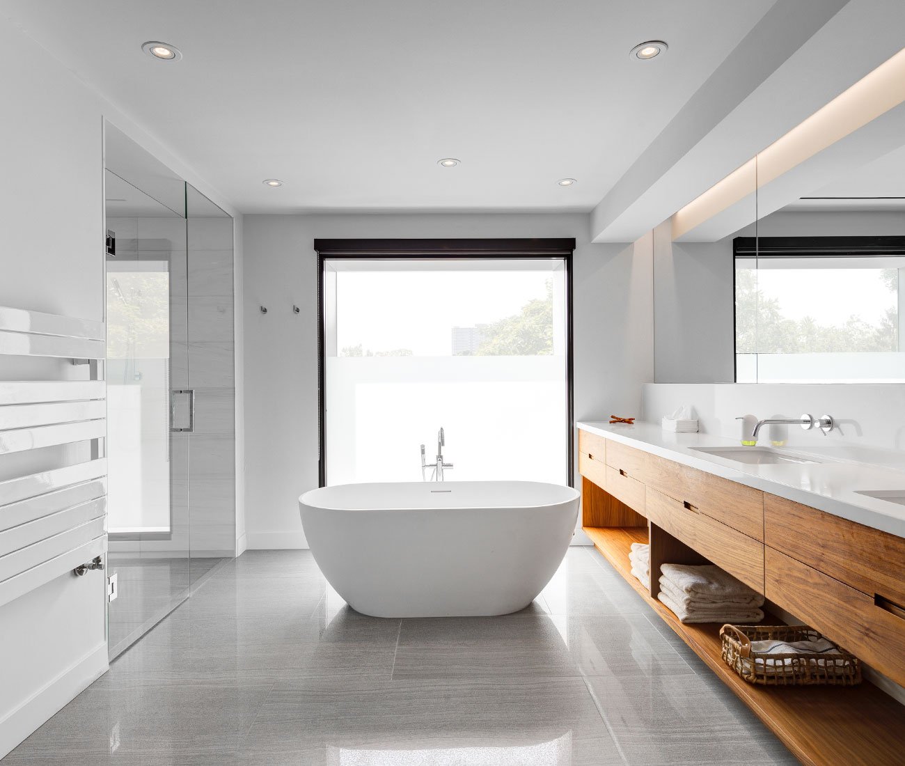 modern bathroom designs - A freestanding bathtub paired with an extended vanity featuring dual sinks