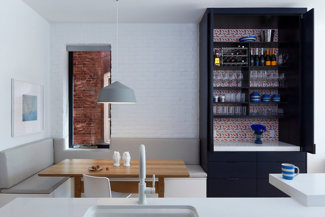 Modern kitchen with navy butler’s pantry and white seating nook.