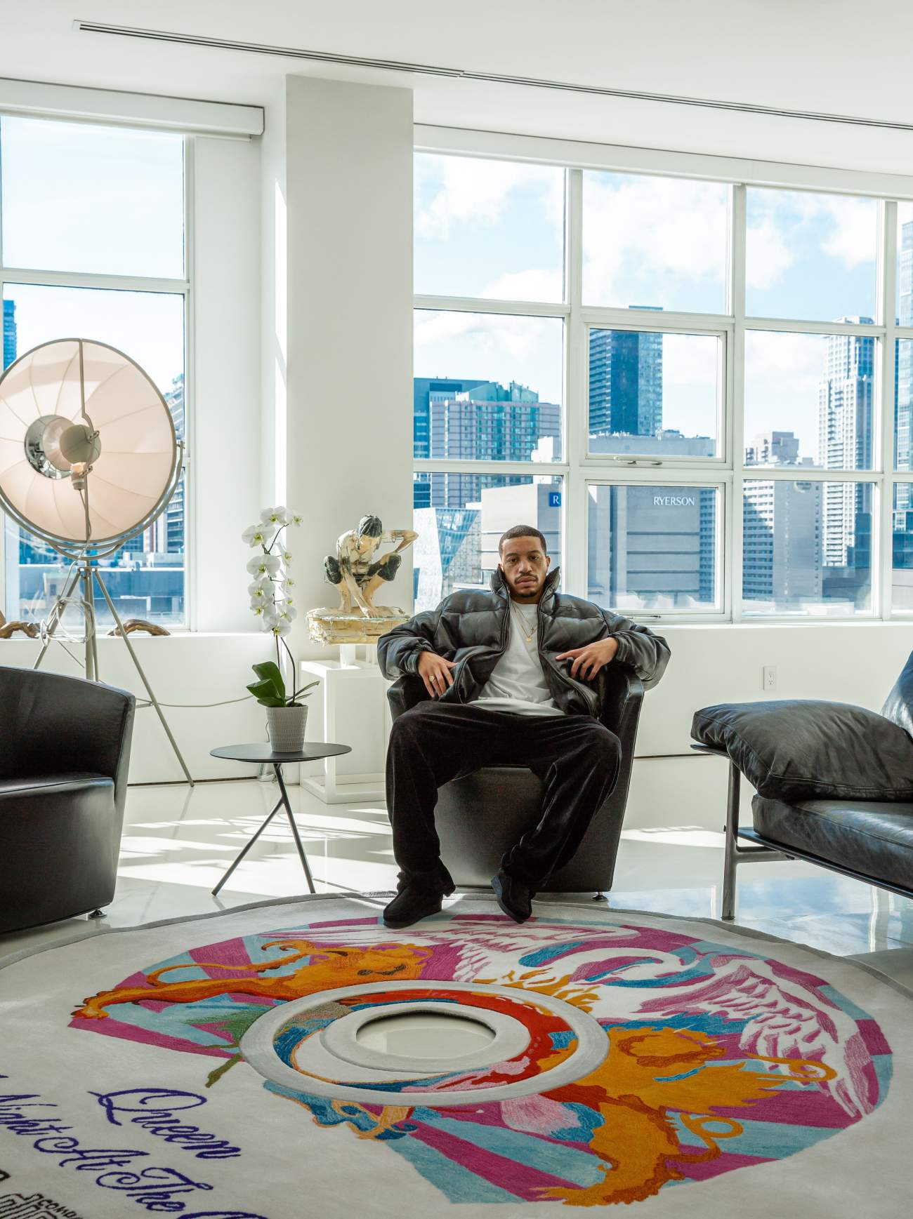 Sean Brown sits in front of his scaled-up CD rugs