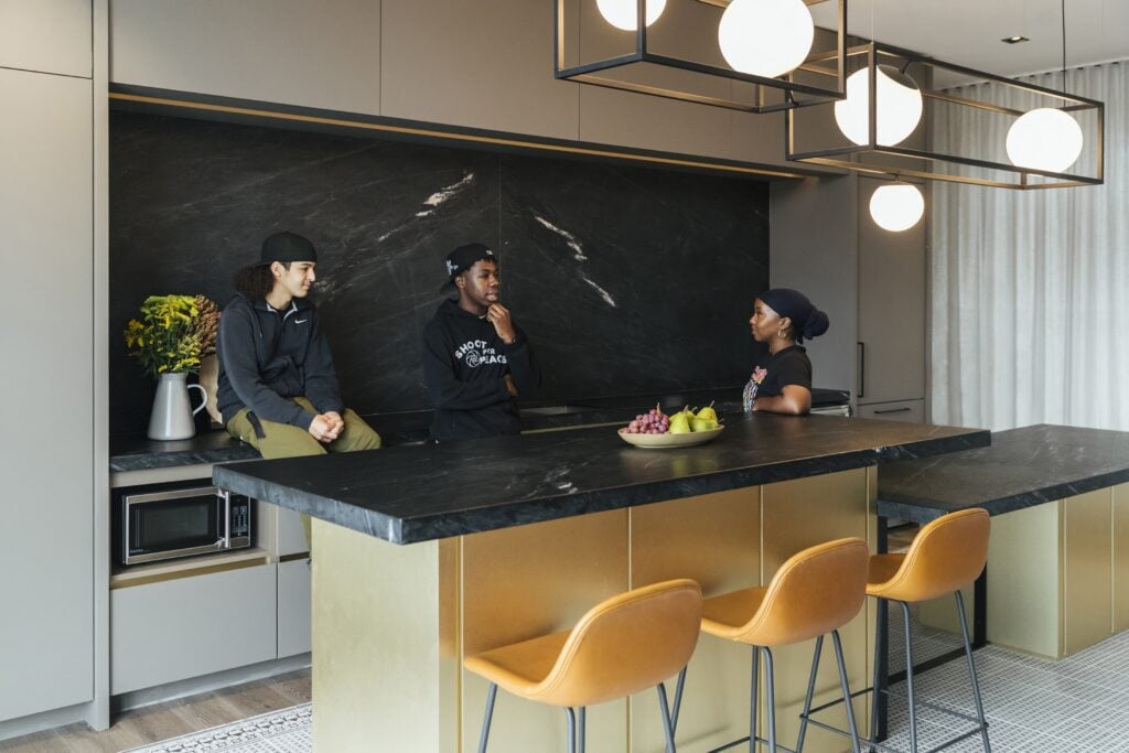 young people in a model kitchen at DuEast Condo developed by Daniels Corporation