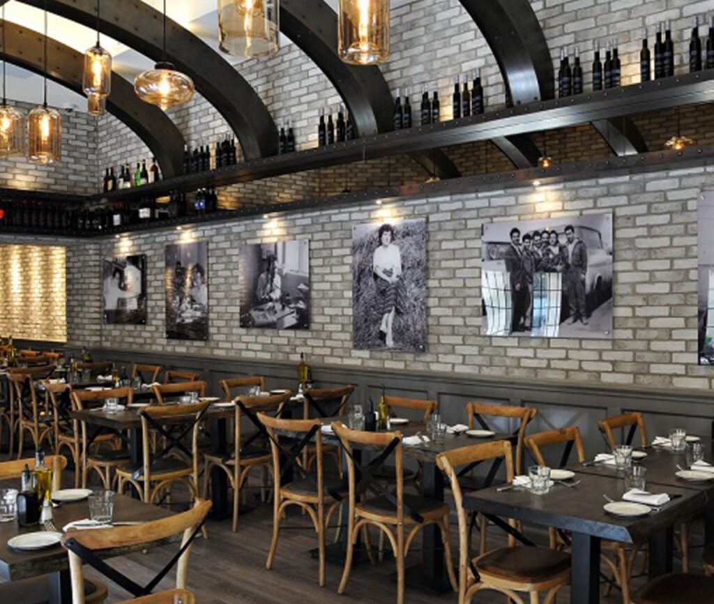 Century Architecture restaurant interior with grey brick wall coverings and dark wood tables and chairs