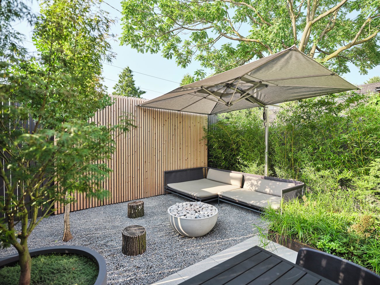Seating area in a small garden with pea gravel.