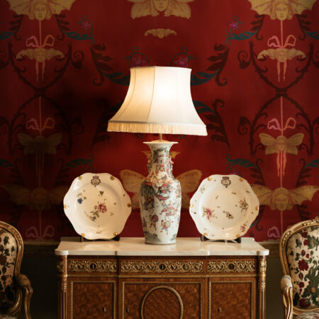 Lamp and two decor plates on furniture, creating a moody Whimsigoth aesthetic.